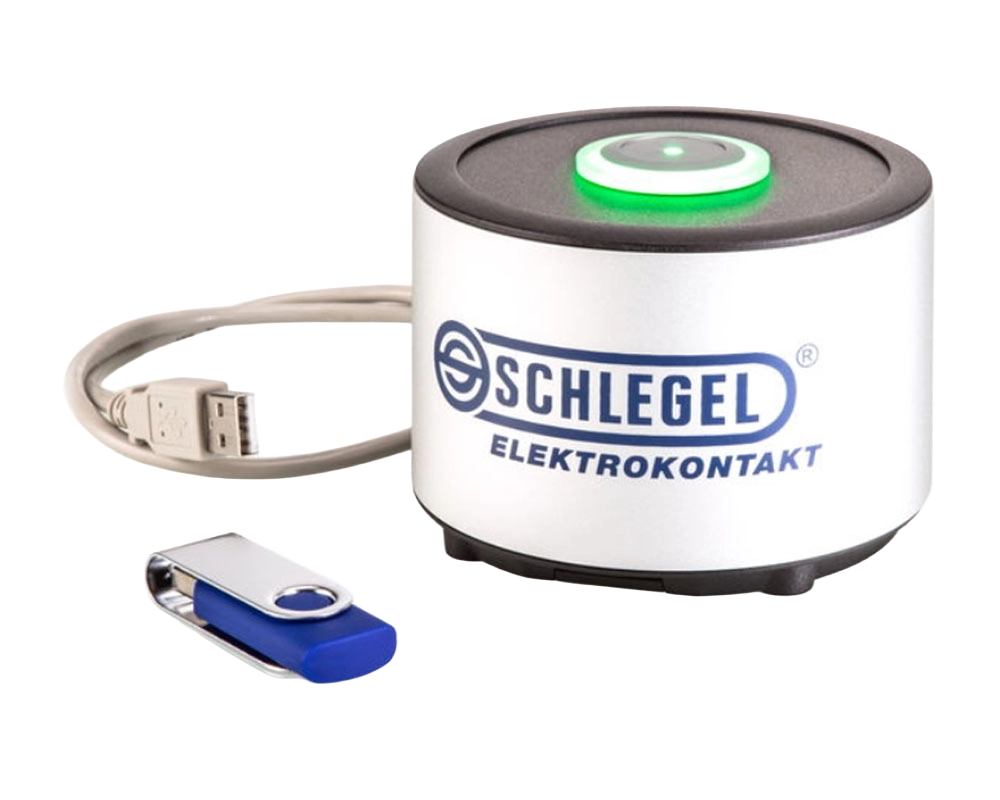Ein silbern-blauer USB-Stick liegt vor einem großen, runden RFID-Lesegerät mit USB-Anschluß. Auf der Vorderseite des RFID-Lesegeräts ist das Logo von Schlegel Elektronkontakte.